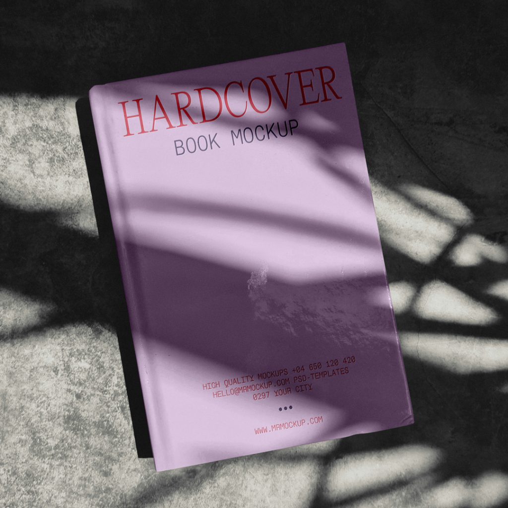 View from above, hardcover book mockup with simple typography design in pink and red color lying on the concrete floor.