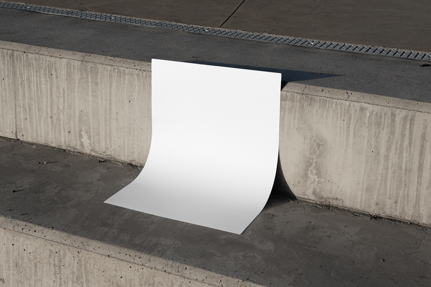 Front view, a white poster mockup leaning against a concrete step.