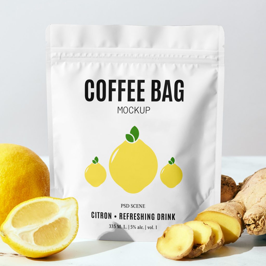 Front view, small coffee bag mockup with bold black typography and simple lemon illustration standing on the table between the lemon and ginger.