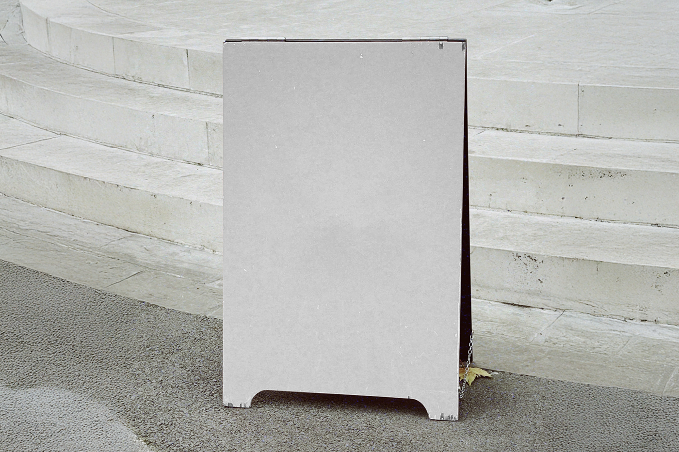 Front view, a white wooden stand mockup standing against marble stairs.