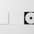 Viewed from above, CD Digipack Mockups presents open white disc packaging lying on the white background.