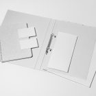 Front view, stationery mockups. Open white binder mockup with a white A4 card mockup and two white business card mockups lying on it. Everything is lying on a white background.