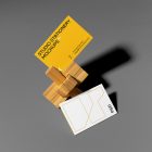 Front view, stationery mockups of two business cards with a wooden toy lying on the gray background.