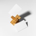 Front view, stationery mockups of two white business card mockups with a wooden toy lying on a white background.