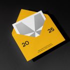 Front view, stationery mockups. An open yellow envelope mockup with black typography protruding from a white square card mockup with a geometric sign. Lying on a black background.