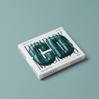 Viewed from above, CD Digipack Mockups presents white disc packaging with nice black serif typography and 3D graphics lying on the green background.