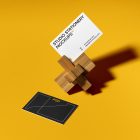 Front view, stationery mockups of two business cards, mockup with wooden toy lying on the yellow background.