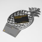 Front view, two business card mockups with strong geometric typography design in black, yellow, and white colors, and also a little geometric sign lying on the background in white color or on a pineapple shaped metal plate in silver color.