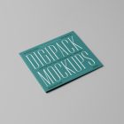 Viewed from above, CD Digipack Mockups presents disc packaging in green color with nice serif typography lying on the gray background.