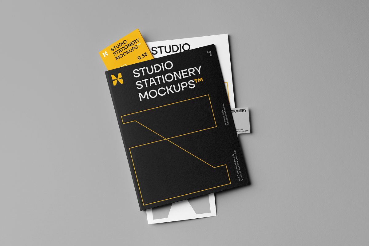 Front view, stationery mockups. A black folder mockup with a protruding yellow leaflet mockup, a white A4 mockup, and a grey business card mockup. Everything is lying on a grey background.