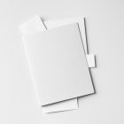 Front view, stationery mockups. A white folder mockup with a protruding white leaflet mockup, a white A4 mockup, and a white business card mockup. Everything is lying on a white background.