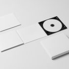 Viewed from above, the composition of CD Digipack Mockups presents three white packages lying on the white background.