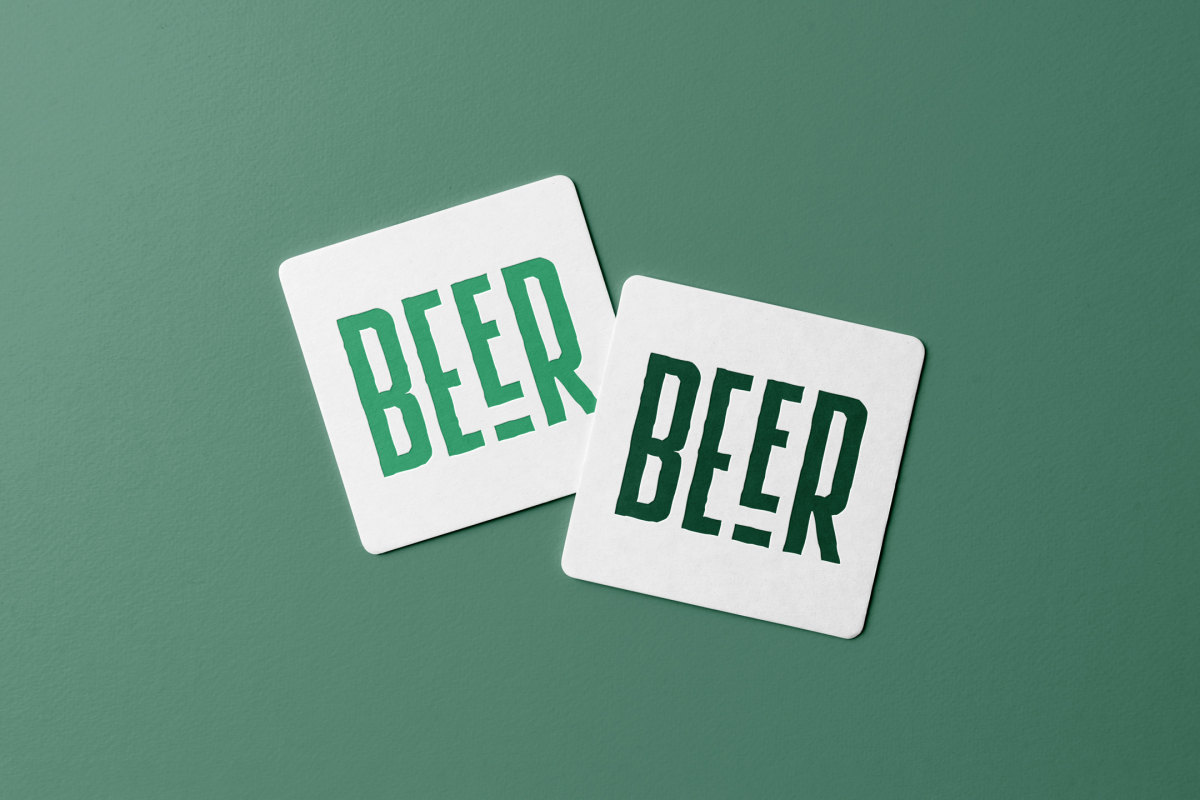 Viewed from above, two beer pad mockups in white and two in green condense the logo lying on the green background.
