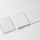 Viewed from above, DVD Mockups presents a transparent plastic package, a white paper box, and a white booklet lying on the white background.