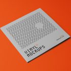 Viewed from above, Vinyl Mockups presents a square music album cover in a gray color with a metal fence graphic lying on an orange background.