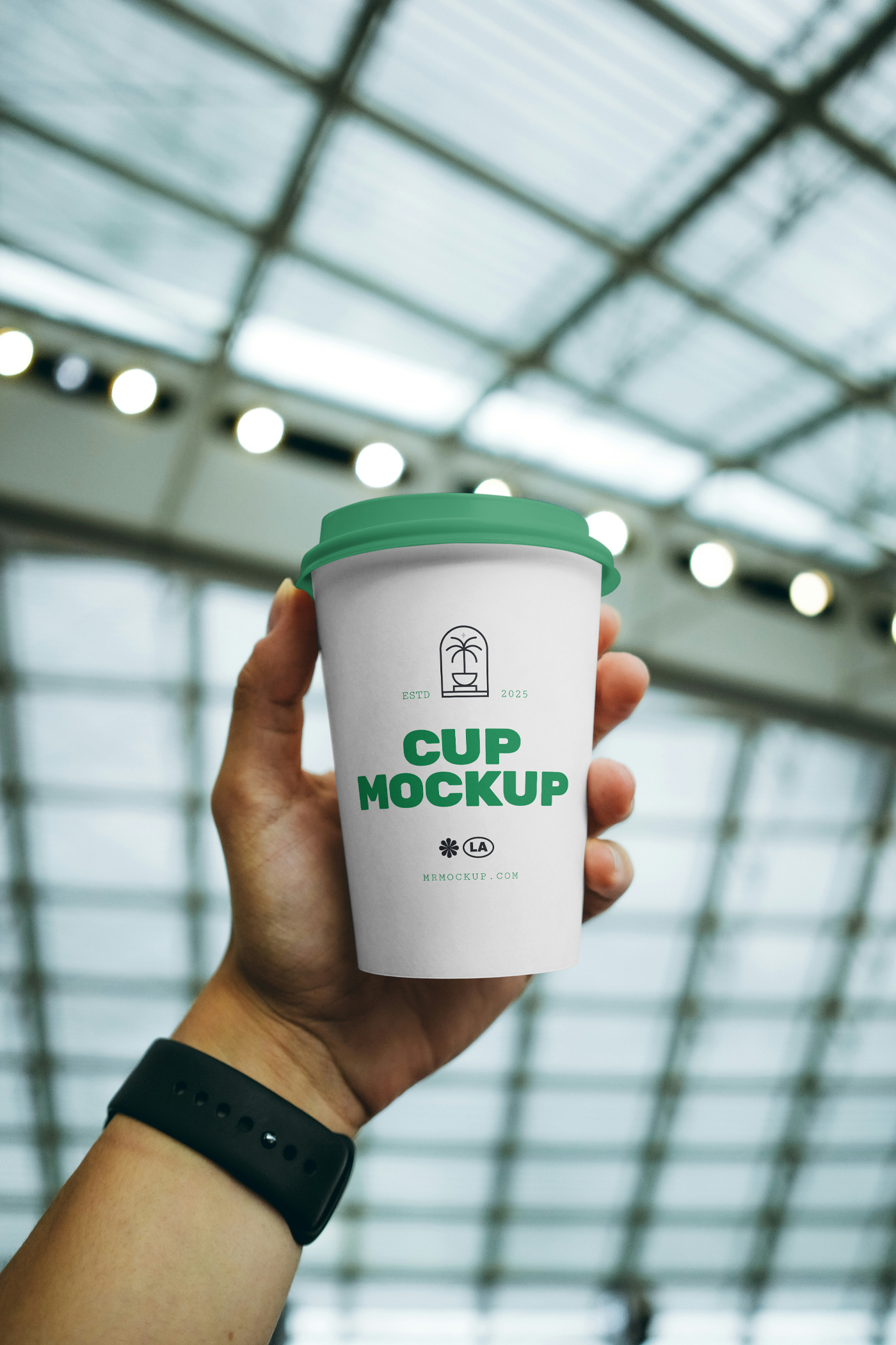Front view of a bright-green coffee cup mockup with a strong typography design held by a man's hand.