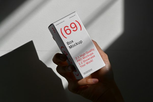 Front view of a white box mockup with a red and black strong typography design held by a woman's hand.