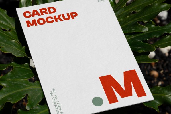 View from above, card mockup with red and green typography design lying between a tropical flower.