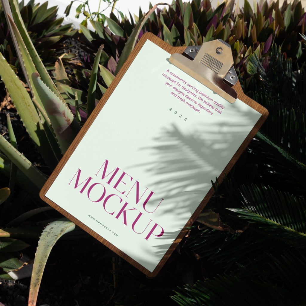 Front view, a menu mockup with green and purple typography design lying between tropical plants.