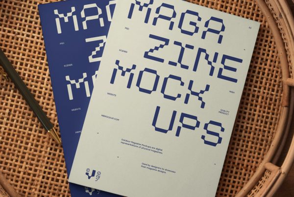 View from above of two magazine mockups with strong navy typography designs lying on a wicker table.