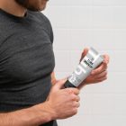 The front view presents men holding a cosmetic tube mockup with a delicate cosmetic design in black, white, and gray colors in both hands.