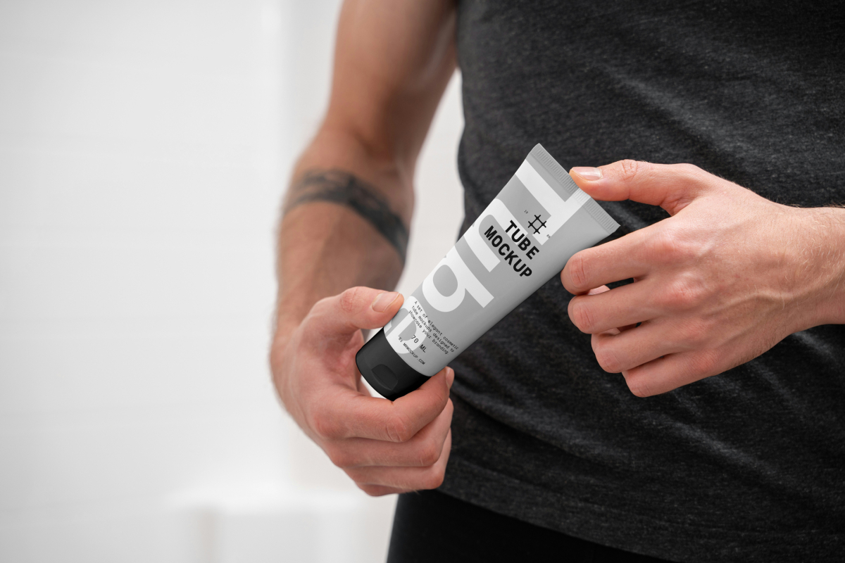 Front view, close up view of men holding a Cosmetic Tube Mockups with delicate cosmetic design in black, white, and gray colors in both hands.