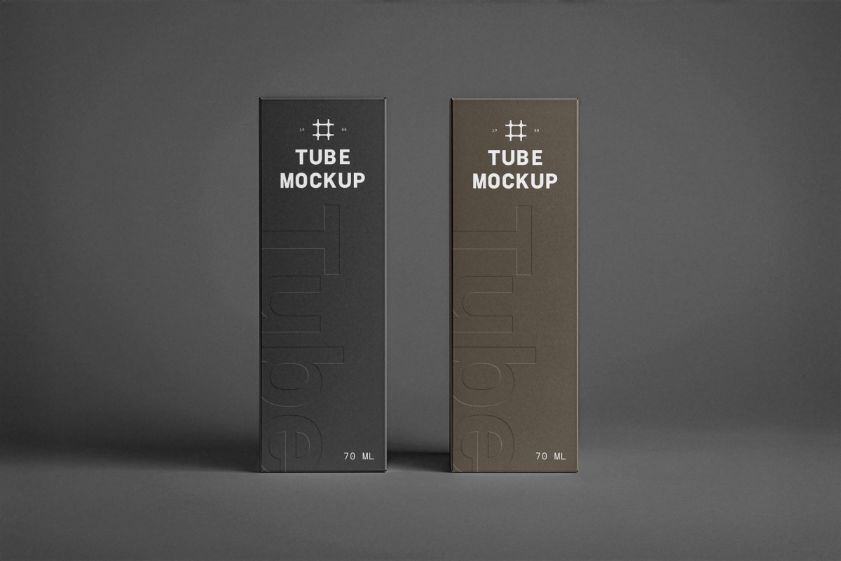 In the front view, two vertical boxes from the Cosmetic Tube Mockups product with delicate cosmetic designs in black, dark green, and white colors stand next to each other on the dark background.