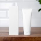 In the front view, a white vertical Box Mockup and a white Cosmetic Tube Mockup stand next to each other on a wooden shelf in the bathroom.