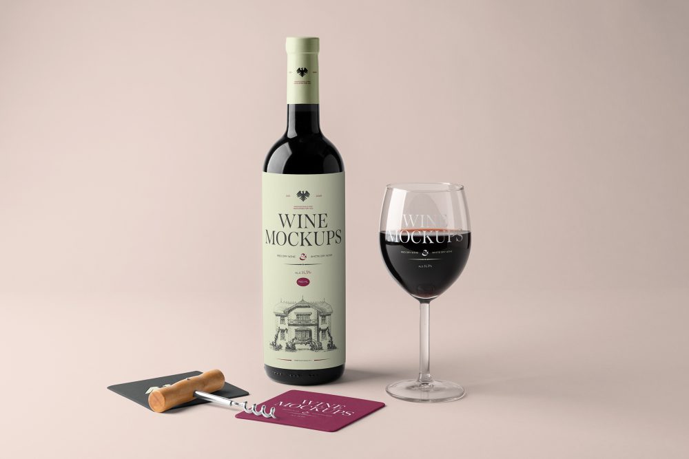 Front view, the scene from Studio Wine Mockups of a standing black wine bottle with a green label, a transparent wine glass with typography design, and two paper pads in dark gray and claret colors on the pink background.