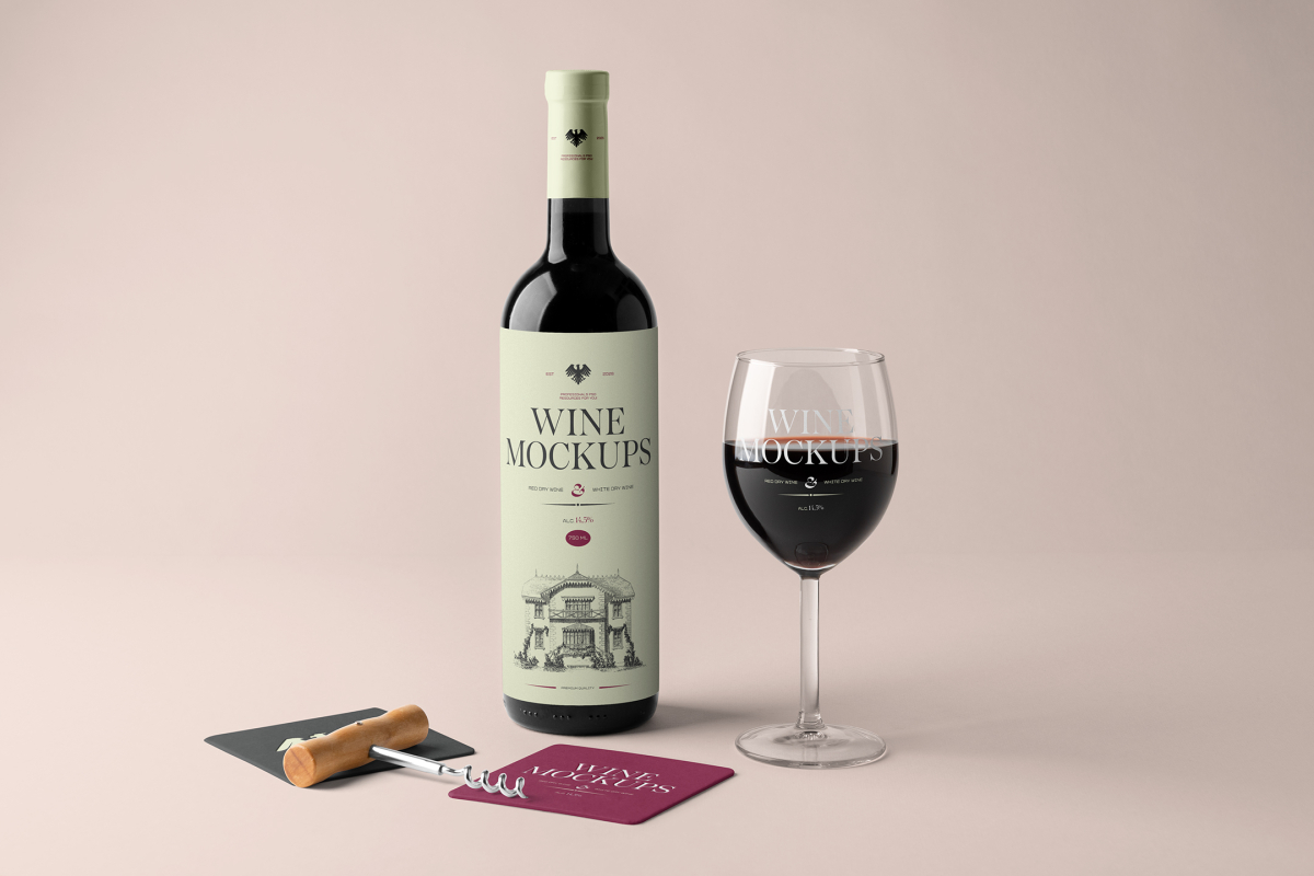 Front view, the scene from Studio Wine Mockups of a standing black wine bottle with a green label, a transparent wine glass with typography design, and two paper pads in dark gray and claret colors on the pink background.
