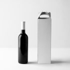 Front view, the scene from Studio Wine Mockups of a standing black wine bottle near a white paper package on a white background.
