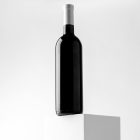 Front view, scene from Studio Wine Mockups of a black wine bottle standing on the white cubic on the white background.