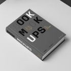 Top view at an angle of a hardcover book mockup in PSD with bold typography design in black, gold, gray, and white colors showing the cover and spine in perspective view on the white background.
