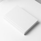 Top view at an angle of a white hardcover book mockup in PSD showing cover and spine in perspective view.