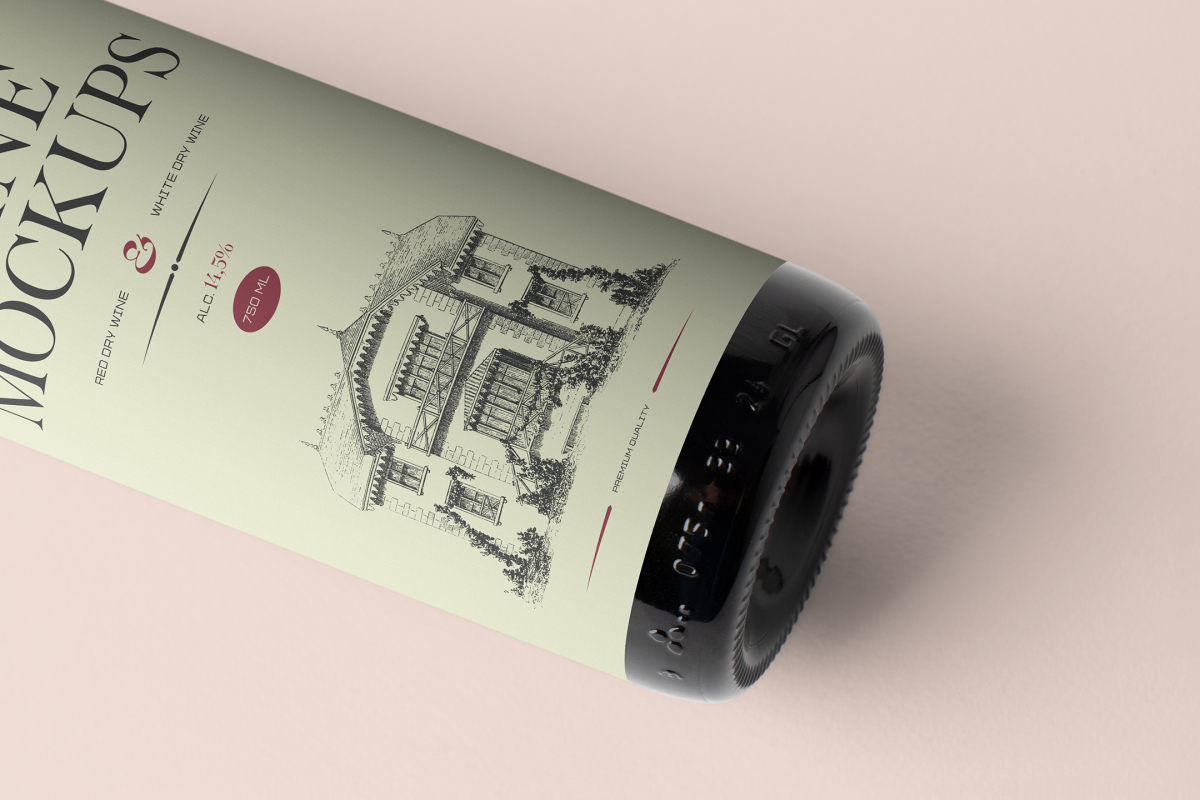 View from above the scene from Studio Wine Mockups of a close view of a black wine bottle with a green label and typography design lying on the pink background.