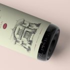 View from above the scene from Studio Wine Mockups of a close view of a black wine bottle with a green label and typography design lying on the pink background.