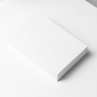 Top view at an angle of a white softcover book mockup in PSD showing cover and spine in perspective view.