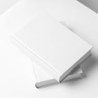 Top view at an angle of two white hardcover book mockups in PSD lying on top of each other showing cover and spine in perspective view.