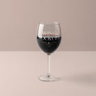 Front view, scene from Studio Wine Mockups of a transparent wine glass with typography design standing on the pink background.