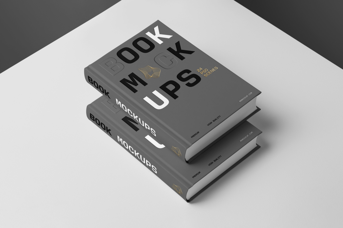 Top view at an angle of two hardcover book mockups in PSD with bold typography design in black, gold, gray, and white colors lying on top of each other for editorial and publishing design.