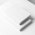 Top view at an angle of two white hardcover book mockups in PSD lying on top of each other for editorial and publishing design.