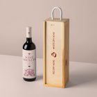 Front view, scene from Studio Wine Mockups of a standing black wine bottle with a pink label and typography design near a wooden wine box with typography design showing a burn effect on the pink background.