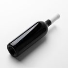 View from above the scene from Studio Wine Mockups of a black wine bottle lying on the white background.