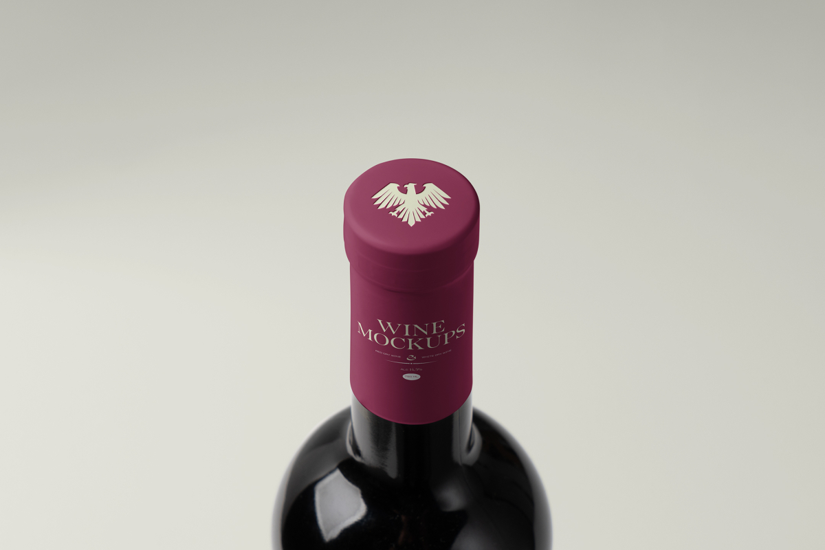 View from above, the scene from Studio Wine Mockups of a standing wine bottle with a claret plastic cap with typography design on the bright gray background.