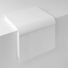 View from above, an open white hardcover book mockup lying on the edge of the white cube.