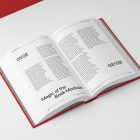 View from above, an open hardcover book mockup with typography text design in black color lying on the white background in perspective view.