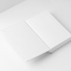View from above, a white open hardcover book mockup lying on the white background in perspective view.