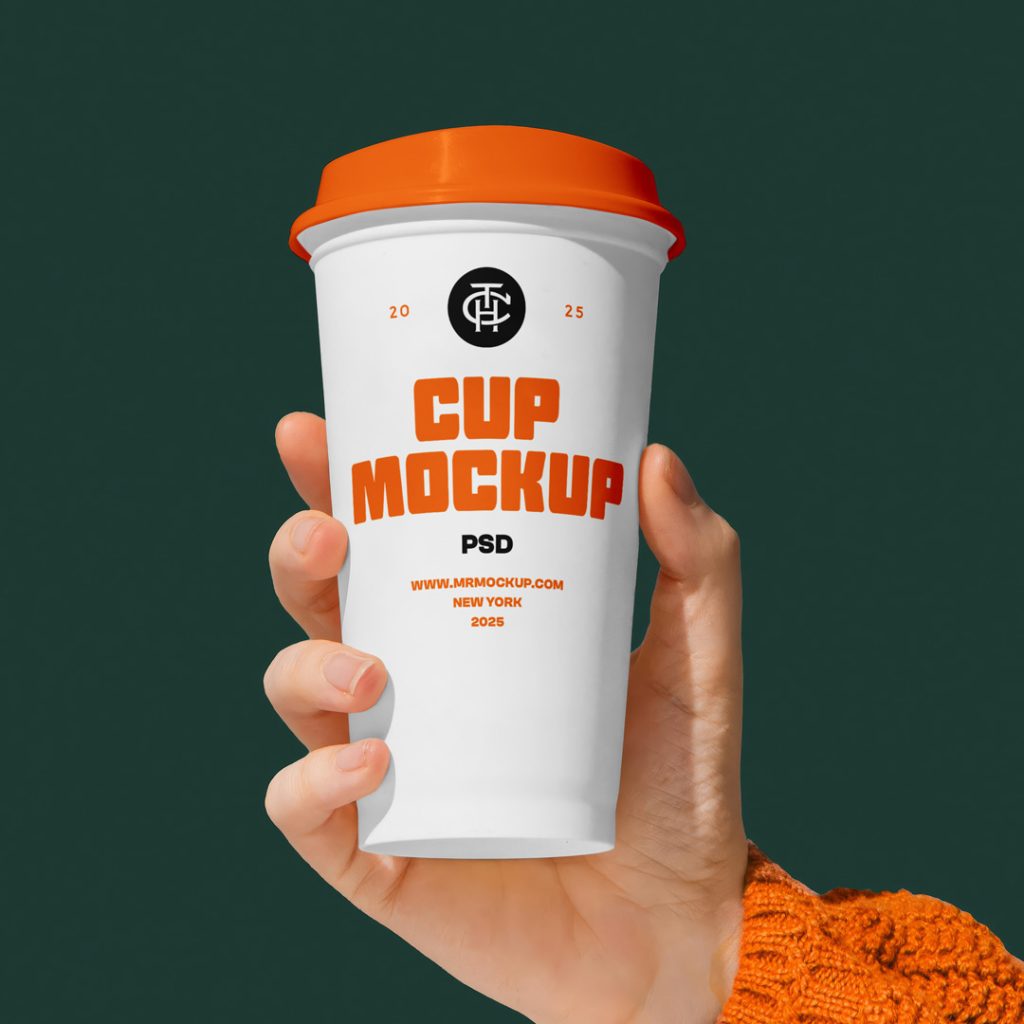 Front view of a white coffee cup mockup with a strong typography design held by a woman's hand.