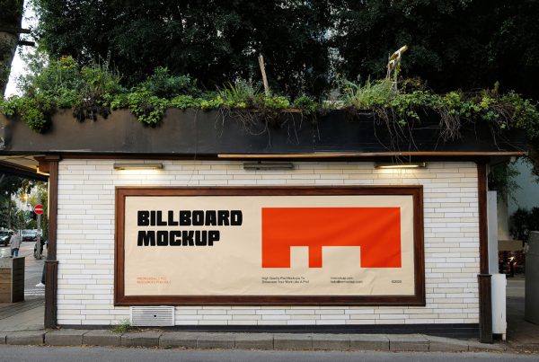 Front view, horizontal billboard with a golden frame and strong typography design in black and orange colors attached to the building's white brick facade.