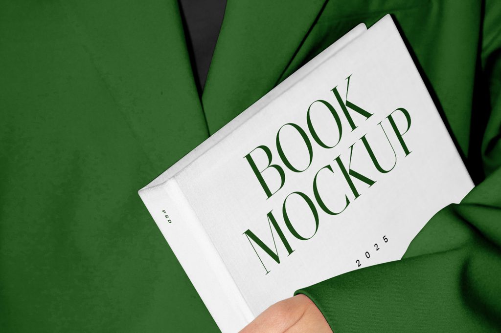 Front view, woman holding white book mockup with delicate serif typography, design in green and black colors, and in the background you can see her green wardrobe.